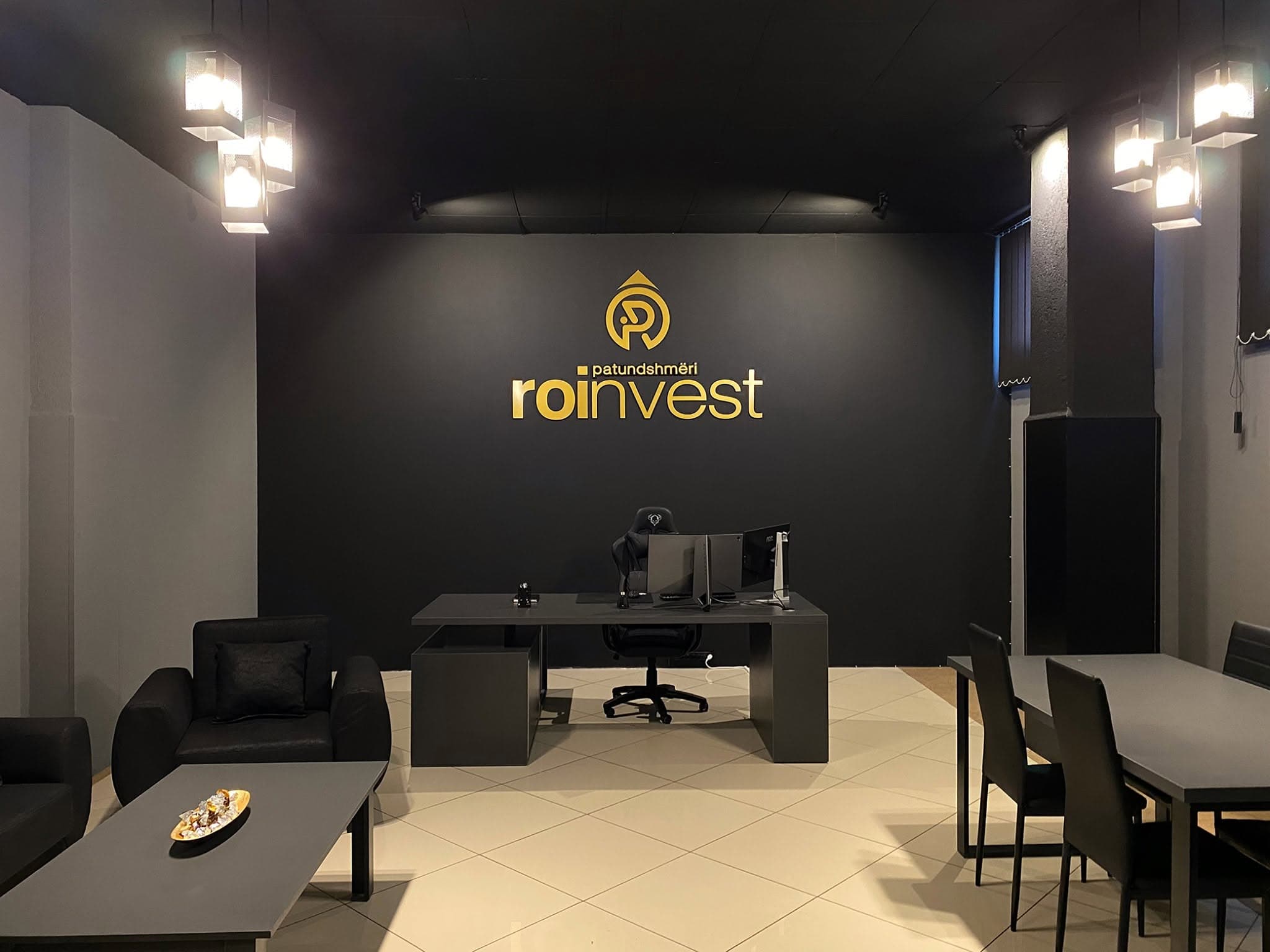 Zyra e parë e Roinvest në 2020 — logoja e artë në murin e zi